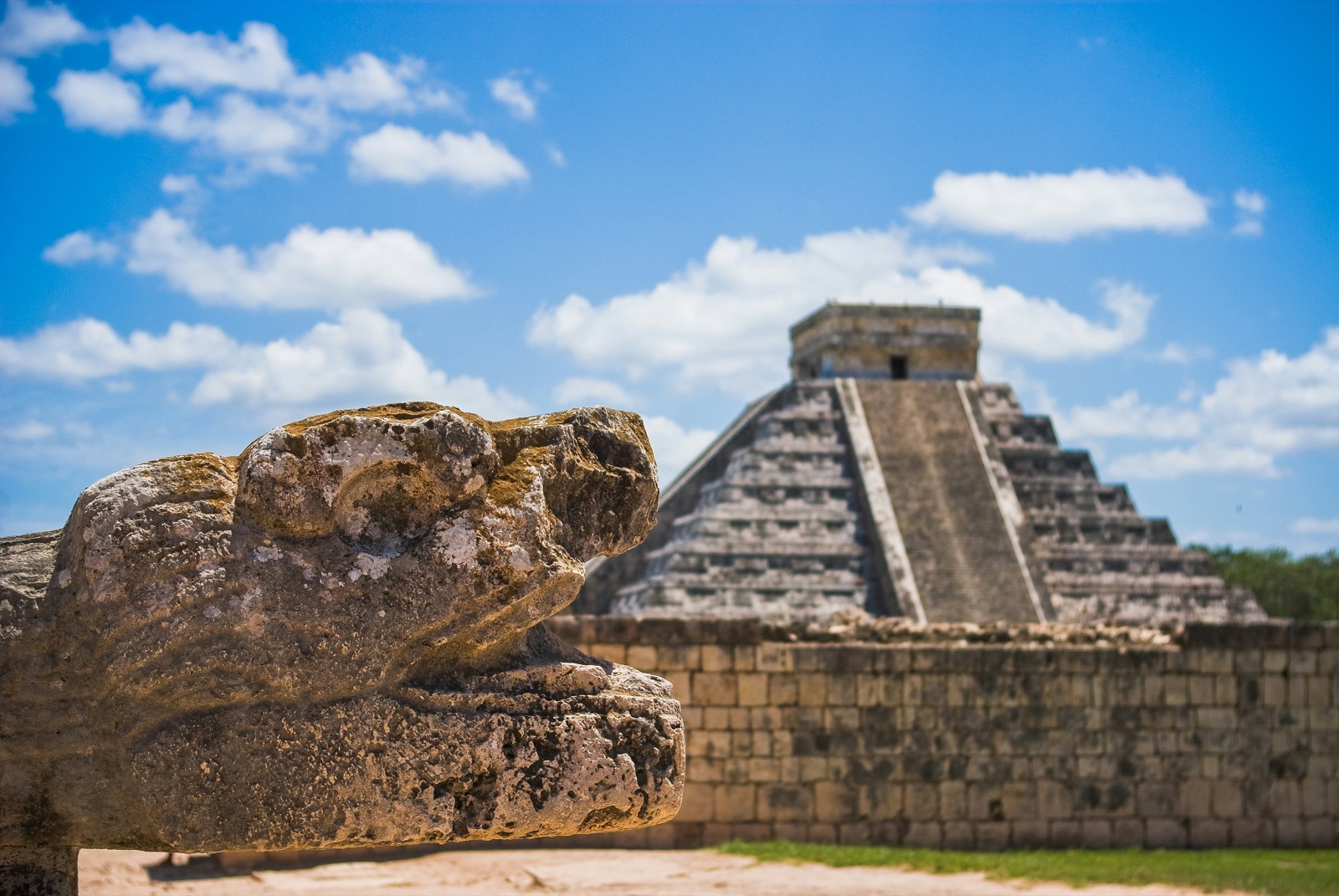 Pyramída El Castillo v Chichén Itzá a kamenná hlava hada v popredí