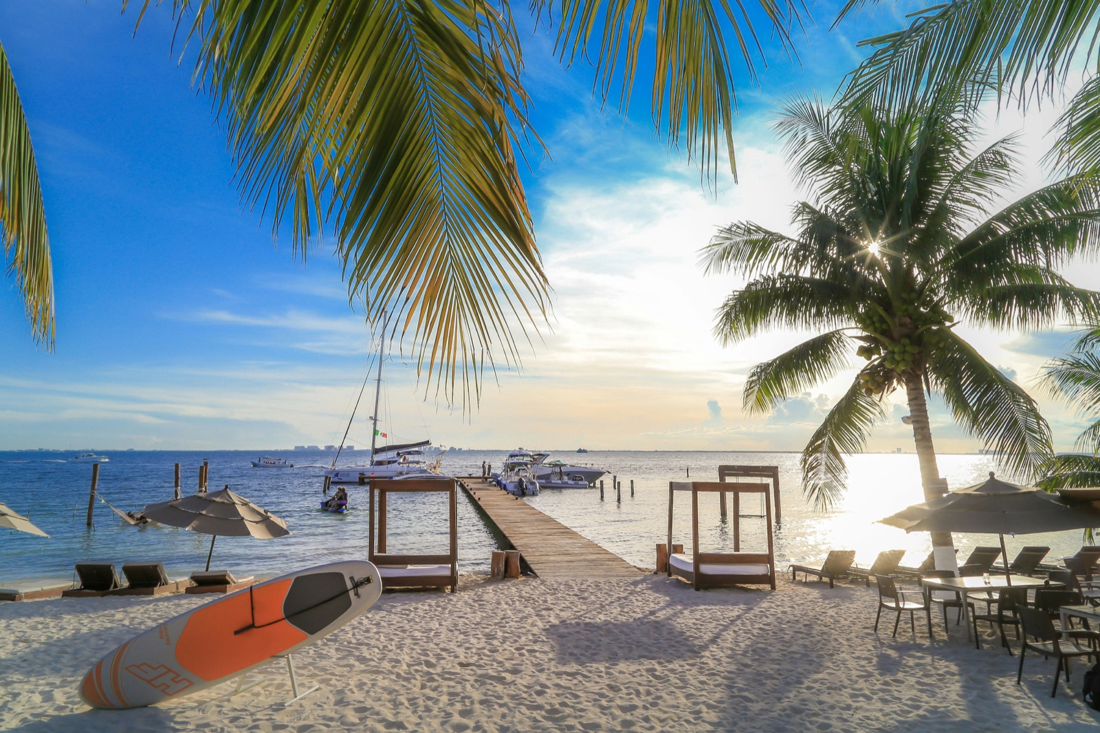 Mólo a pláž s palmami pri západe slnka na ostrove Isla Mujeres