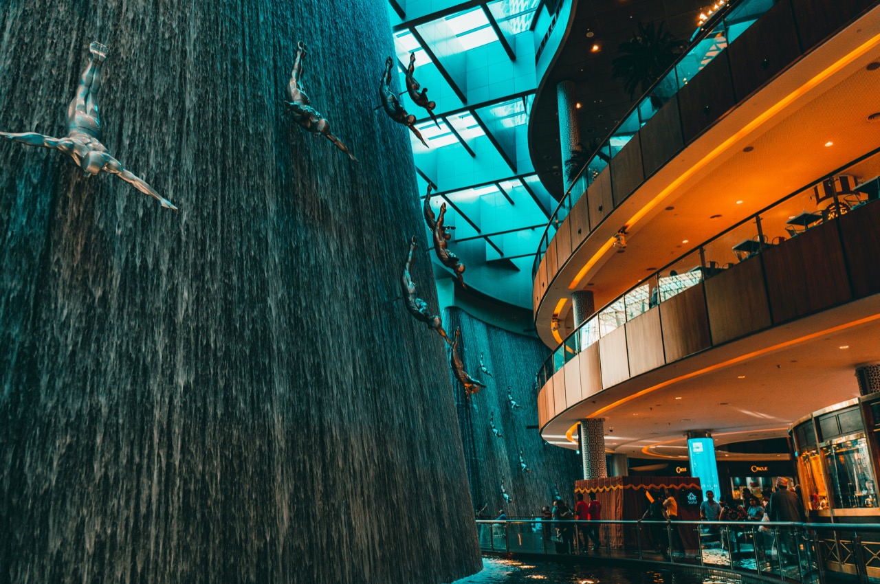 Interiér nákupného centra Dubai Mall s umelým vodopádom a sochami