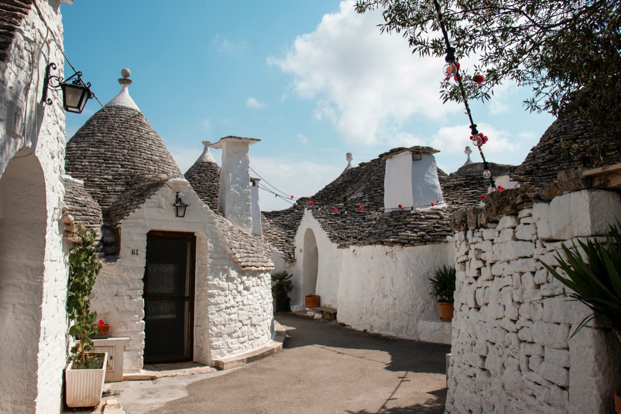 Bielo natreté domy trulli s kužeľovými strechami v Alberobelle