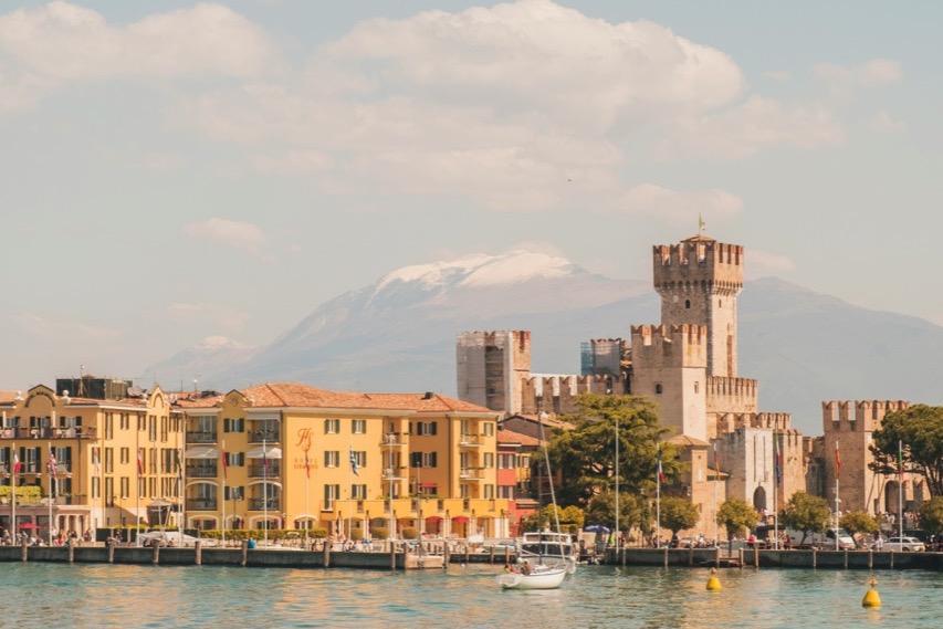 Hrad Scaligeri v Sirmione na Gardskom jazere so zasneženým vrchom v pozadí