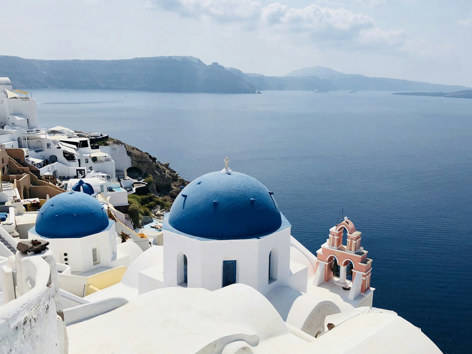 Biele domčeky s modrými kupolami v Oii na ostrove Santorini
