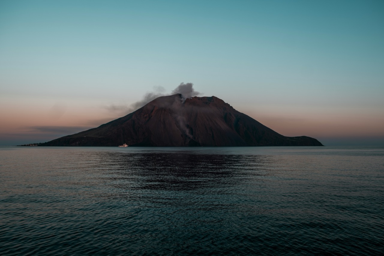 Ostrov Stromboli so sopkou a dymom pri súmraku