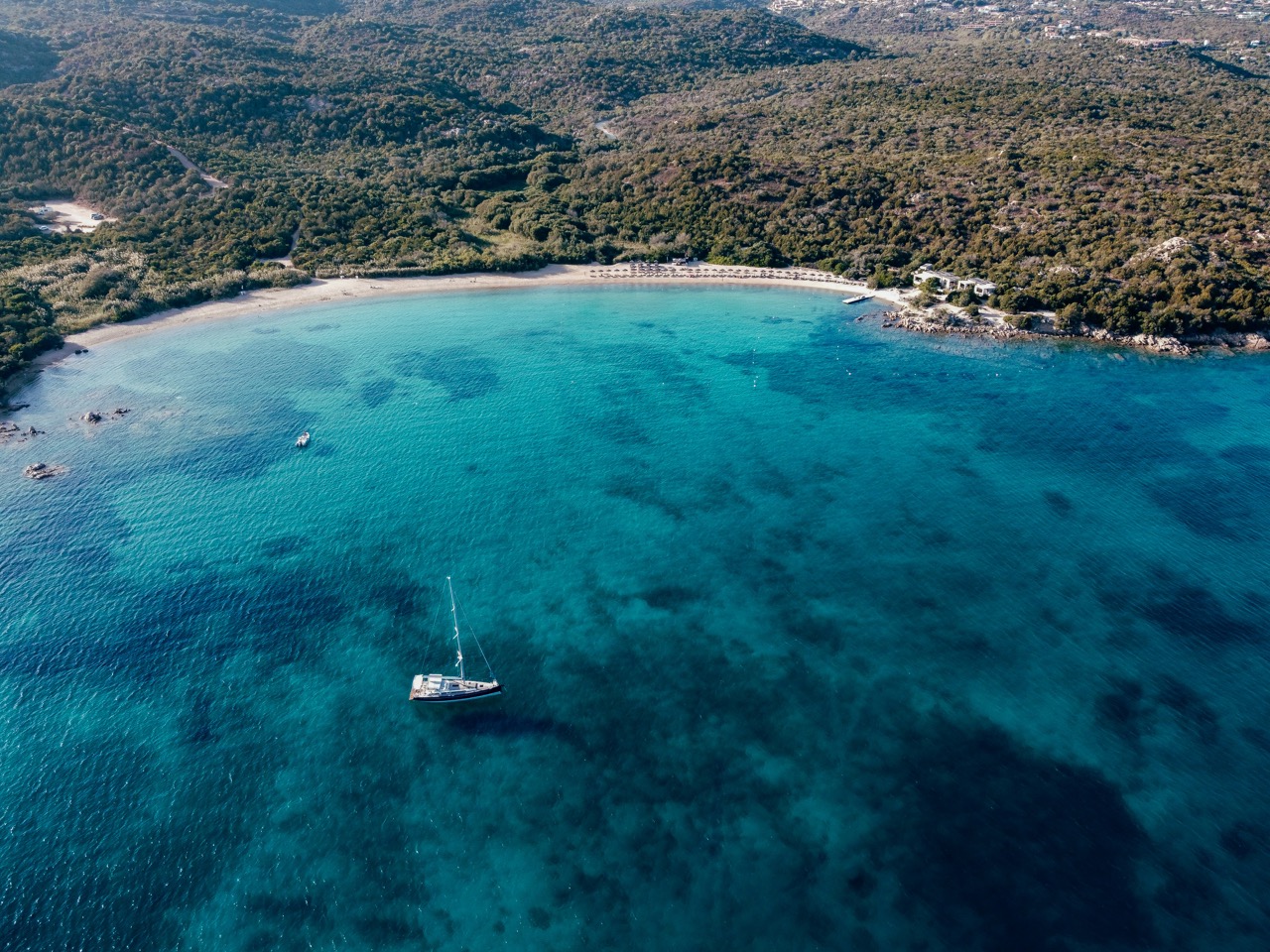 Letecký pohľad na zátoku pri Costa Smeralda s plachetnicou