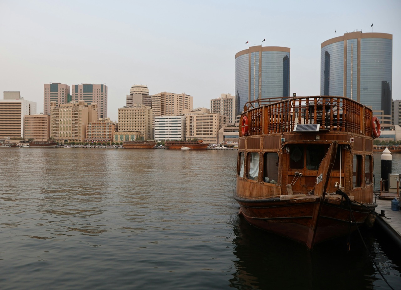 Tradičná drevená loď dhow na Dubai Creek s mrakodrapmi v pozadí