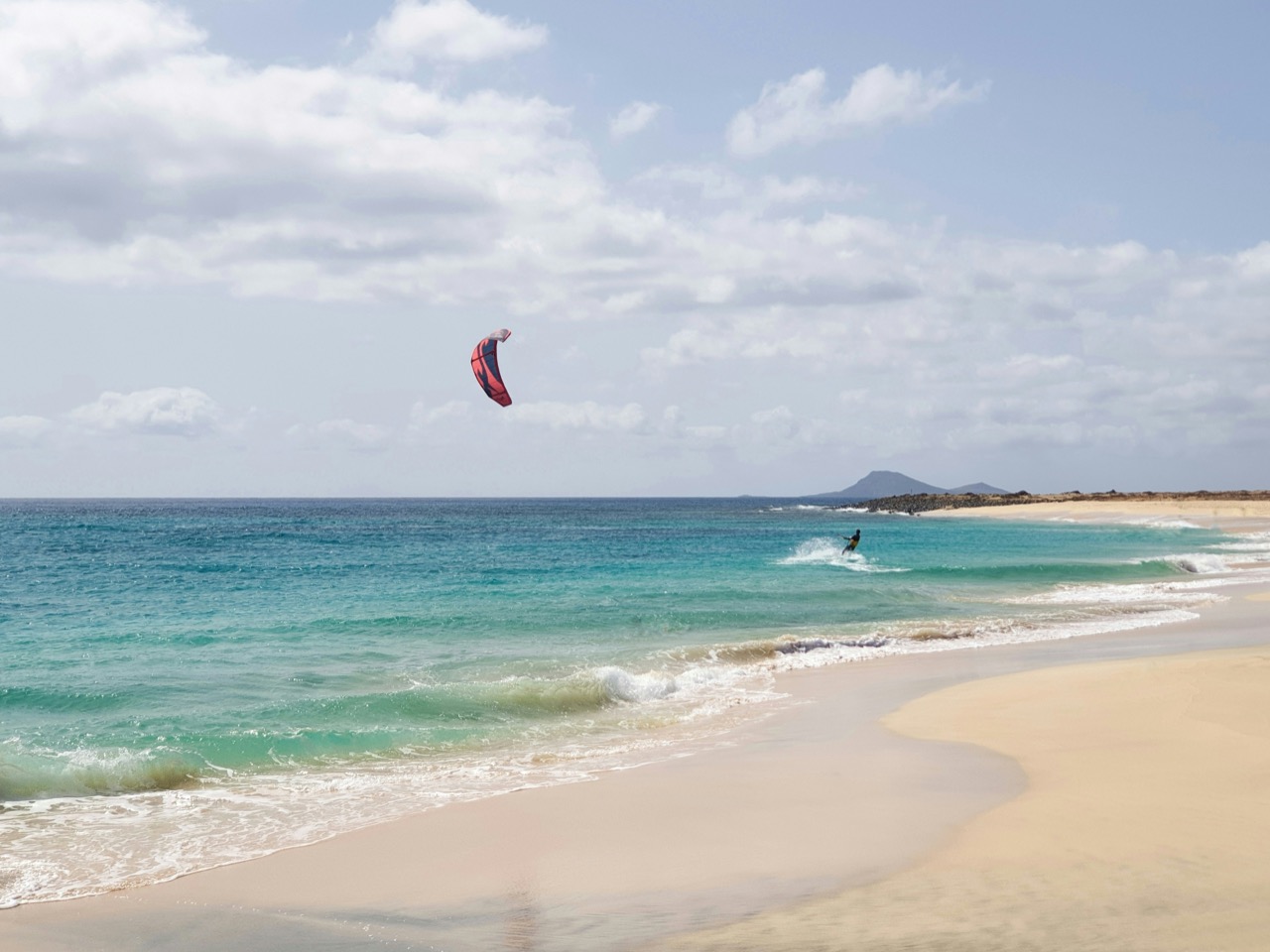 Kitesurfista na vlnách pri pláži na Sal